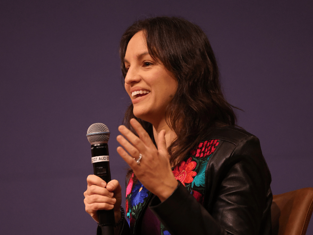 Journalist Monica Guzman speaking into a microphone.