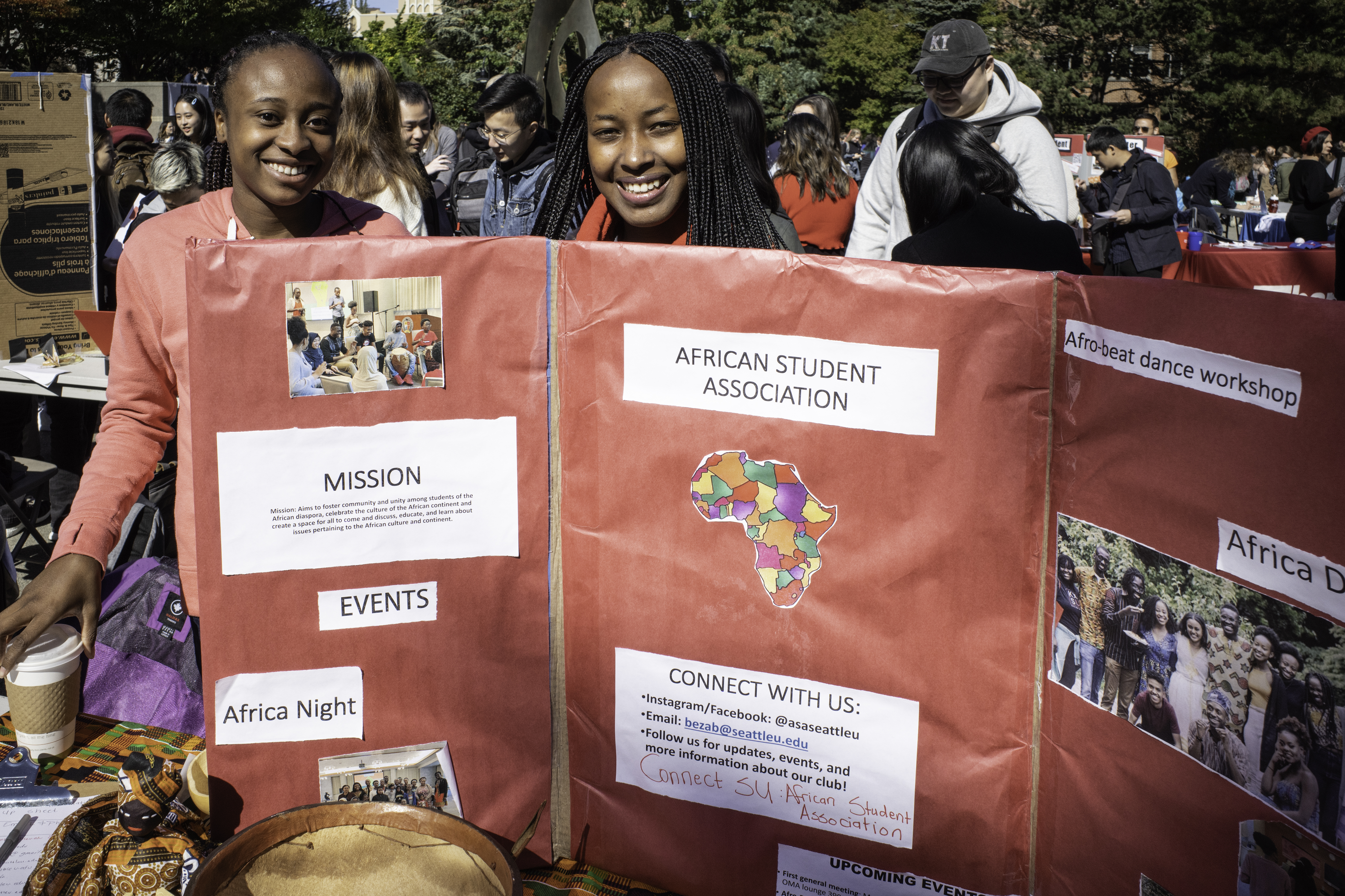 2 students stand with a poster at an outdoor fair