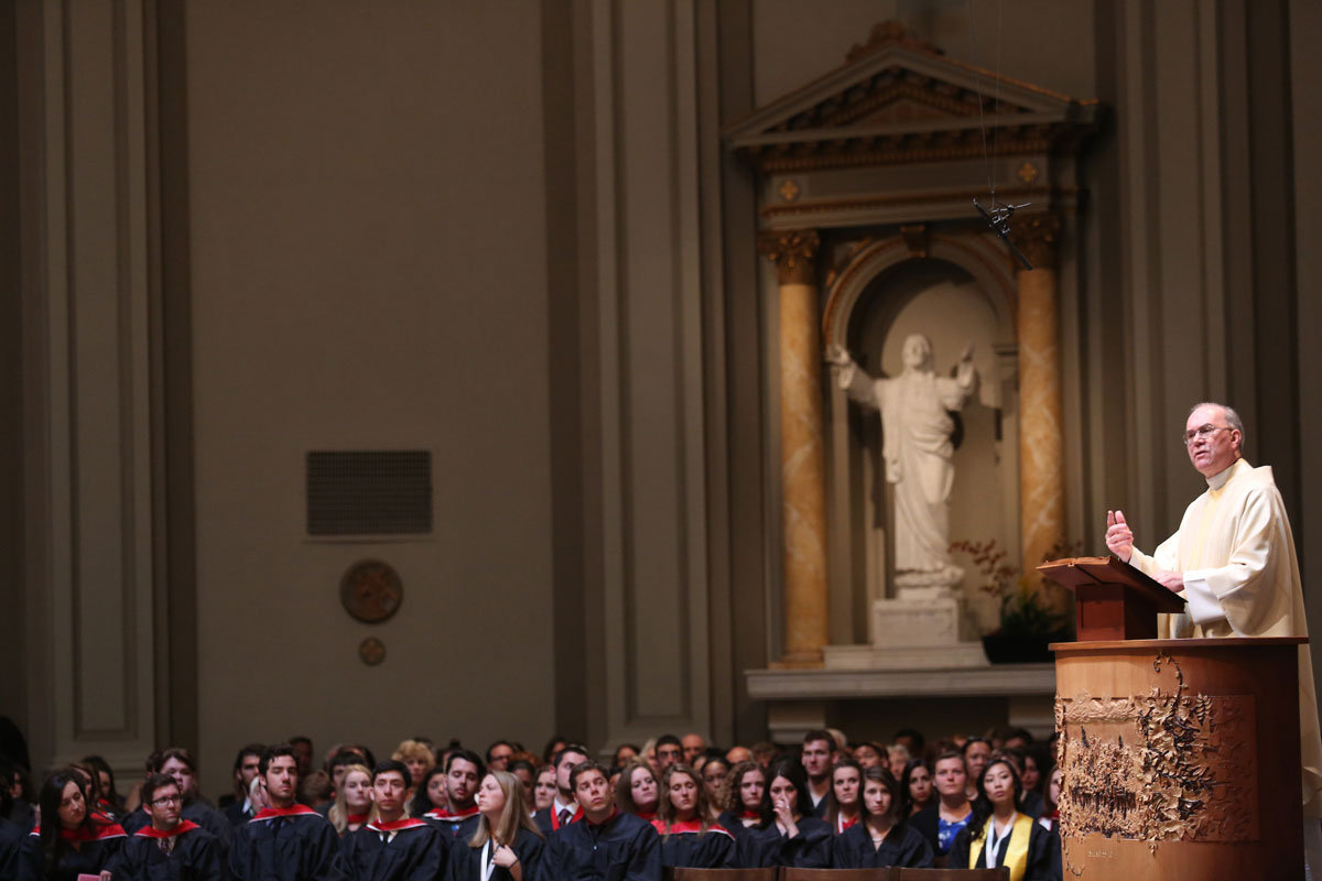 Fr. Sundborg addresses graduating students inside a Capitol Hill church