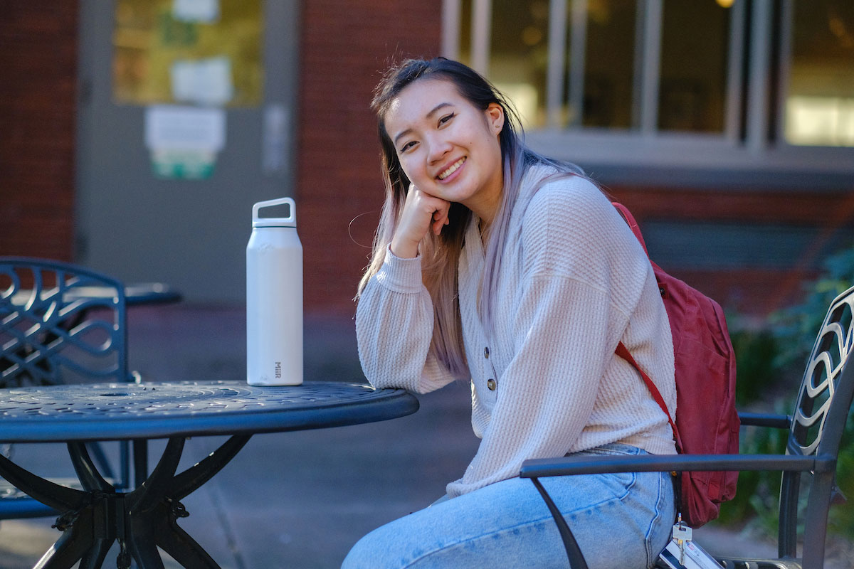 Student Adeline Ong sits at a table on campus.