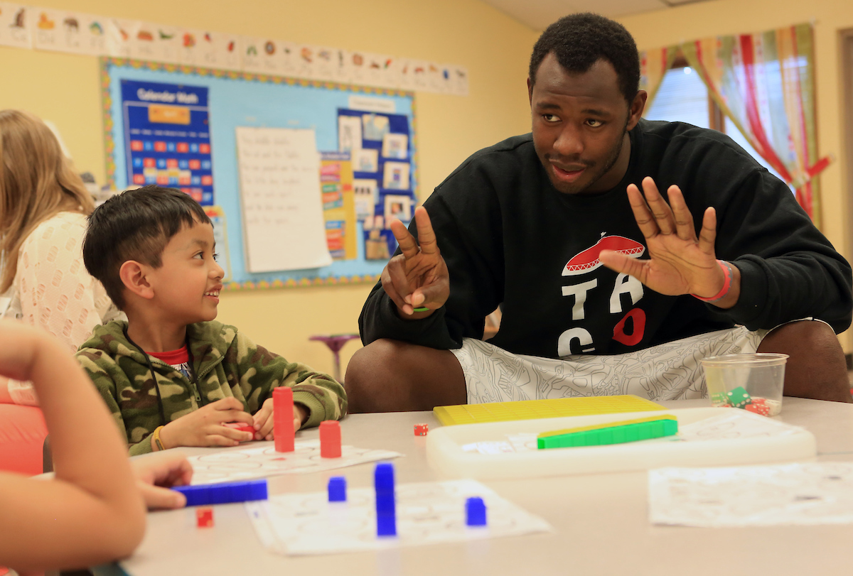 Seattle U basketball player engaging with elementary school students