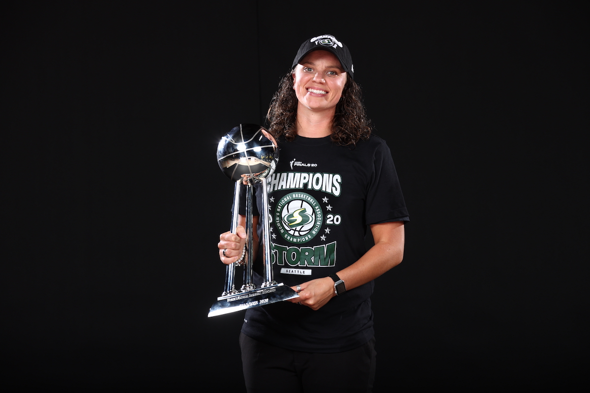 Image of Talisa Rhea holding the championship trophy of Seattle Storm.
