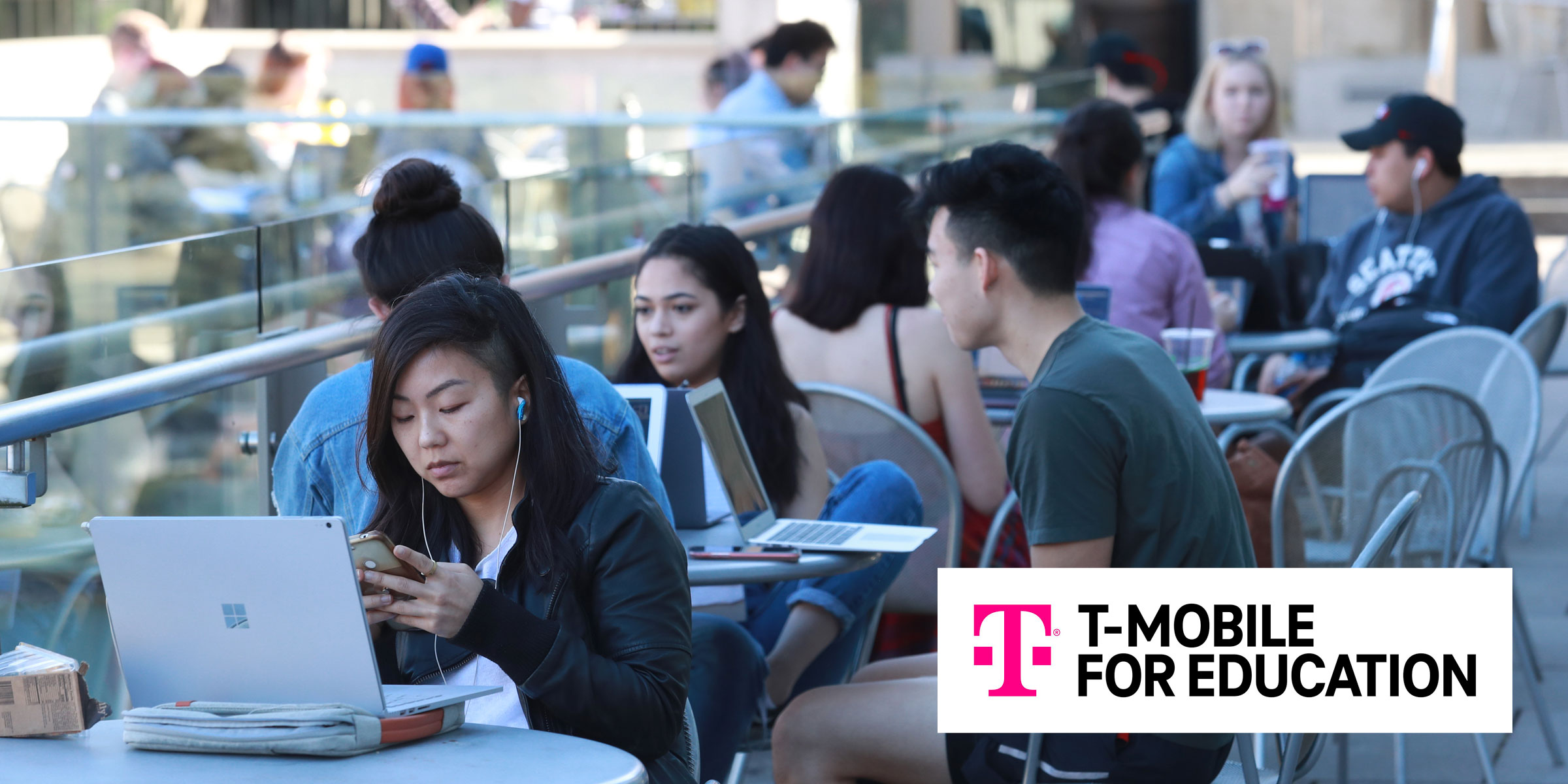 A graphic featuring T-Mobile logo and students on campus on computers. 