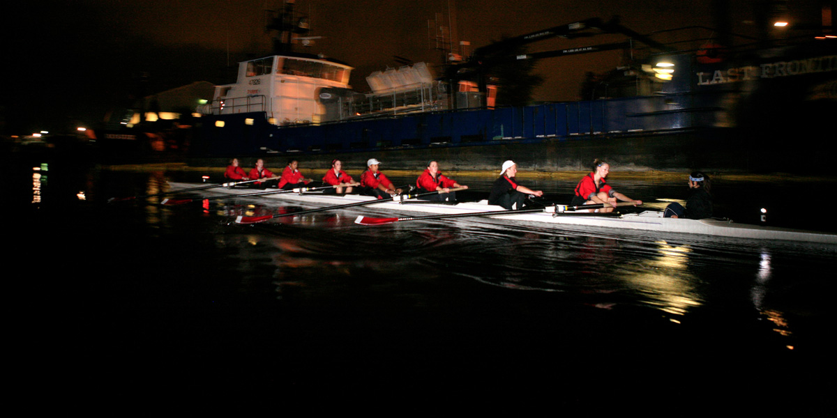 Women's Varsity Crew Team rowing at night