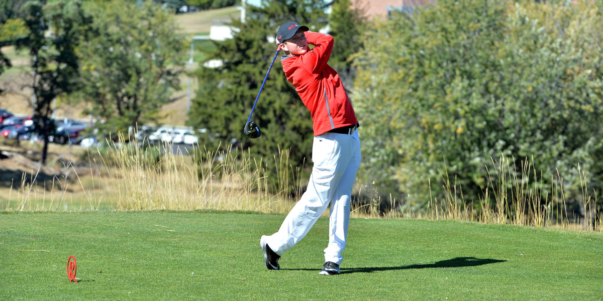 a member of SU Men's Golf watching the ball after a stroke