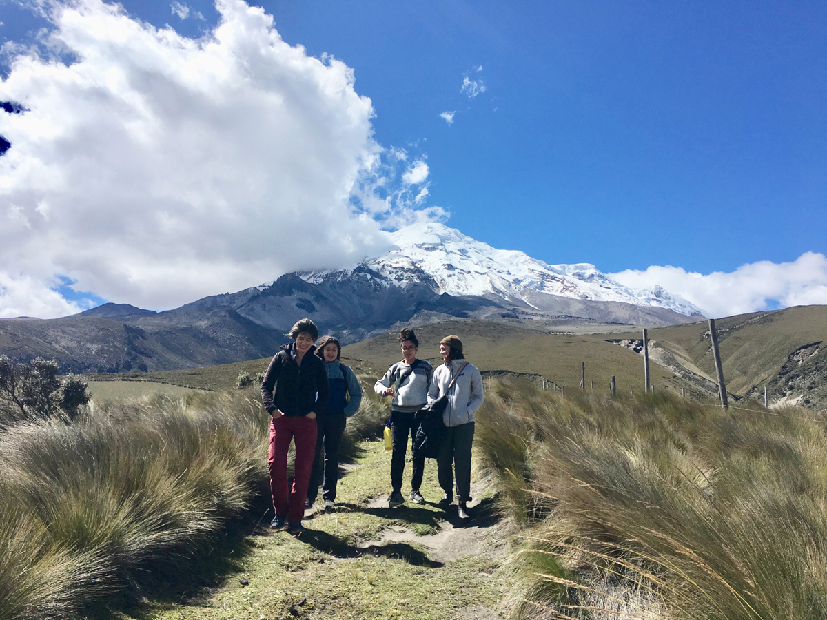   Dr. Tanya Hayes and students walking against a mountain backdrop with blue skies in Ecuador.